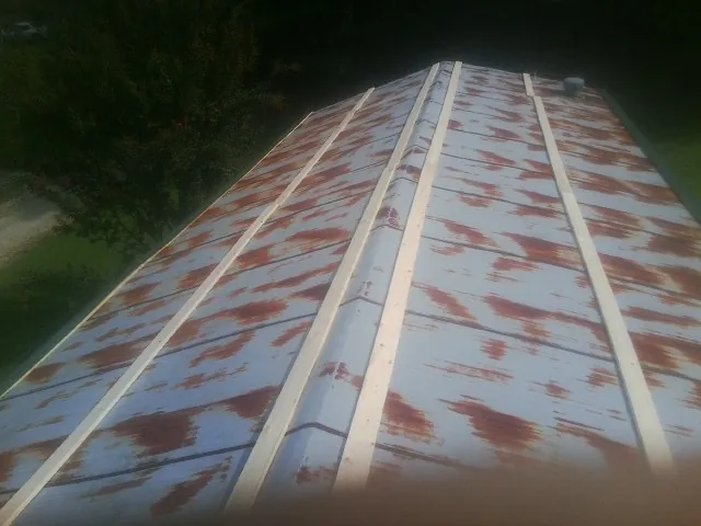 Rusted metal roof panels with new wood purlins before replacement — Storm Damage Roof Repair in Linton by Roofing Brothers