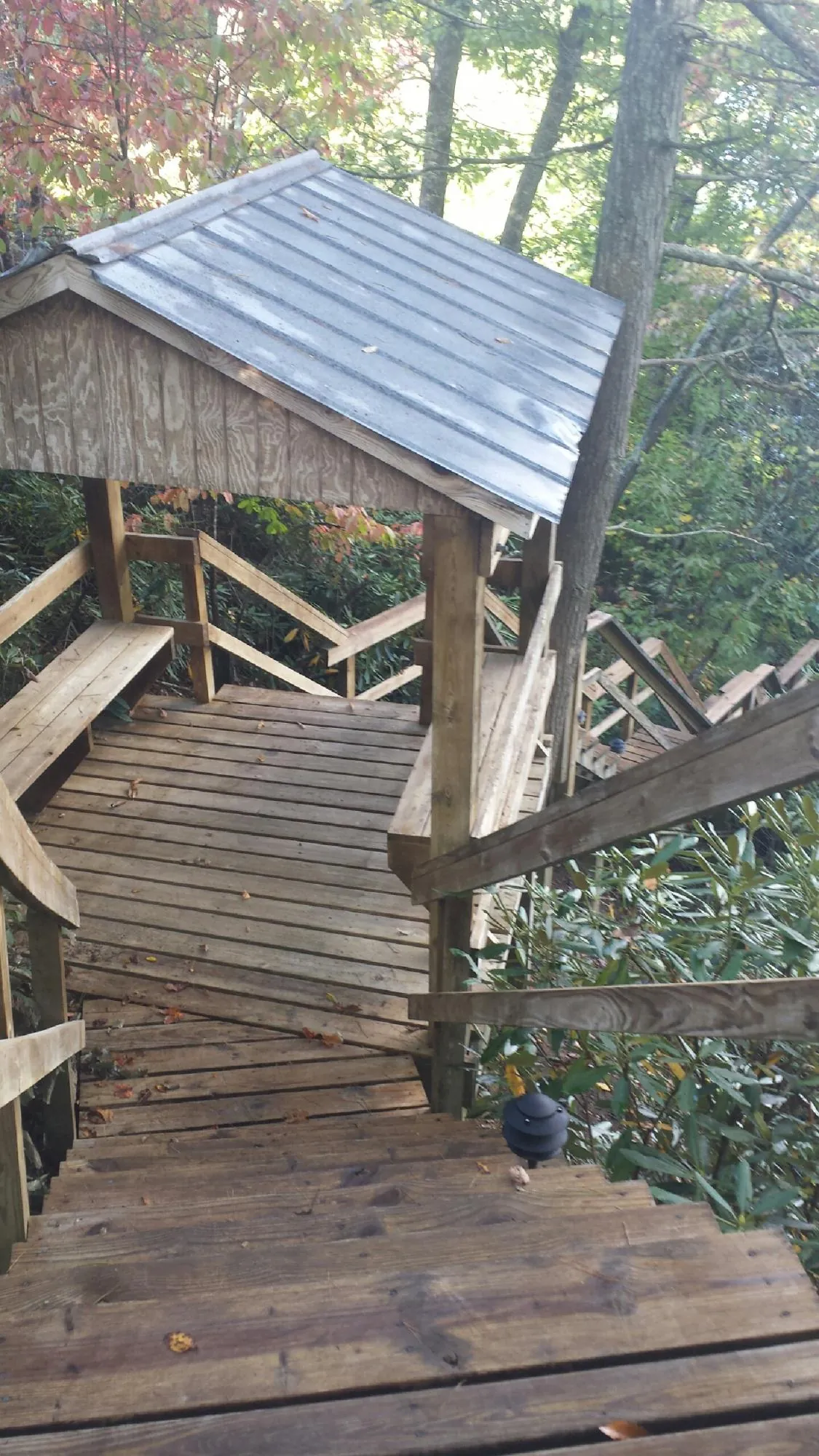 Metal roofed shelter over wooden steps on a wooded walkway — Skylight Repair & Installation work by our crew in Linton