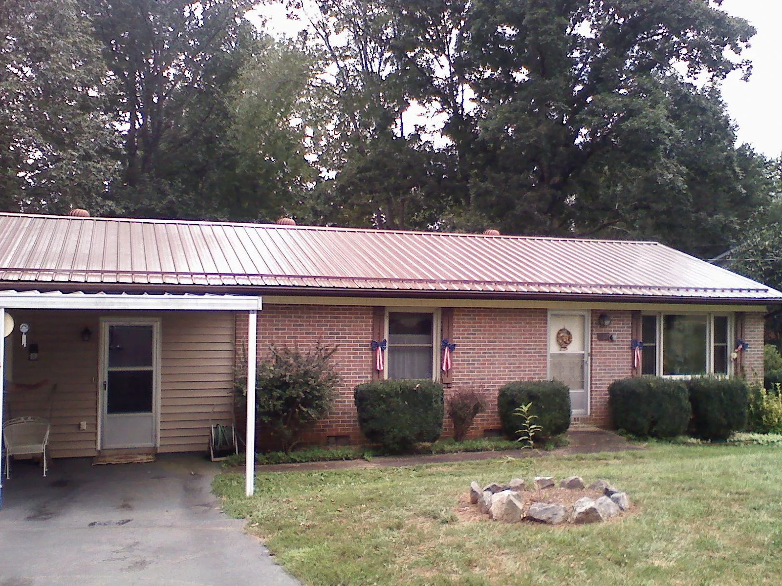 Bronze metal roof and carport on a brick ranch home — Roof Repair work by our crew in Linton