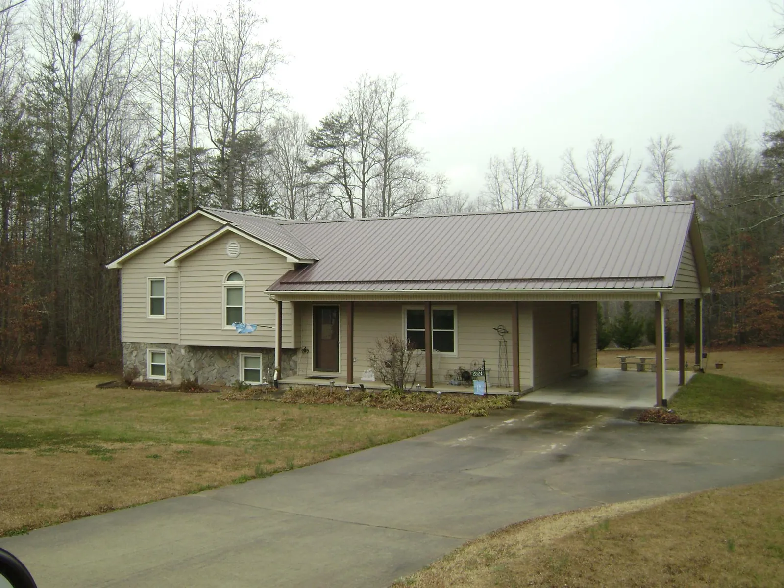 Brown metal roof on a tan split level home with an attached carport in Linton
